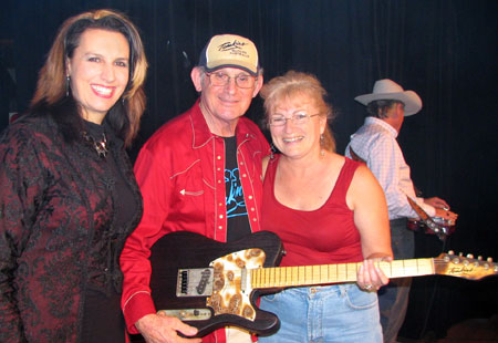 NICKI and ALLAN present a Tomkins Guitar to lucky prize winner GWYNNE