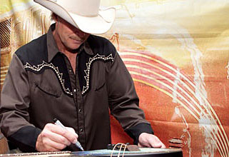 Alan Jackson signing the Tomkins guitar